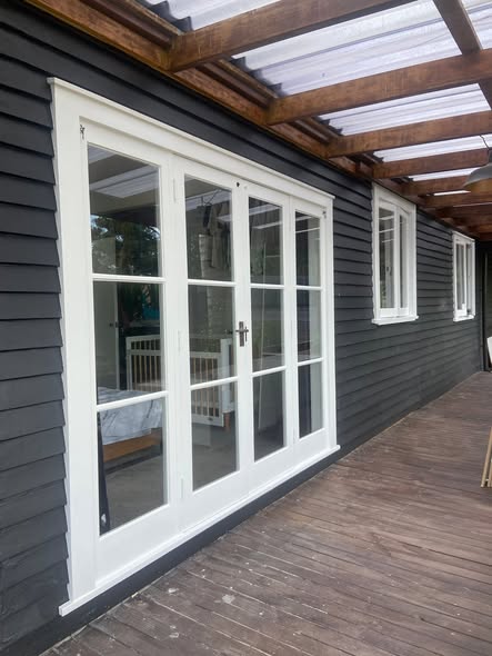 Charcoal weatherboard house with crisp white French doors