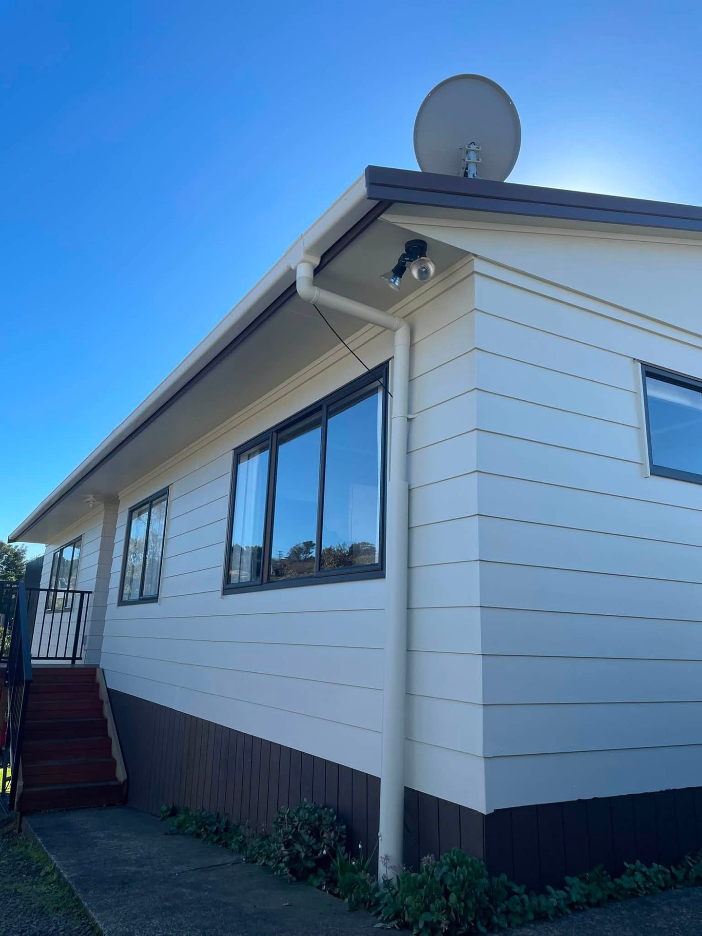 White and grey painted house exterior against a blue sky