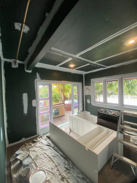 Interior room mid-renovation with dark green feature walls